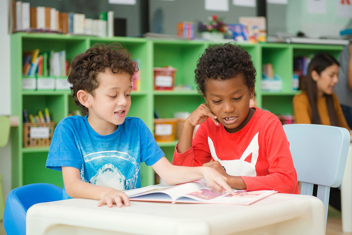 Two boys reading a book together